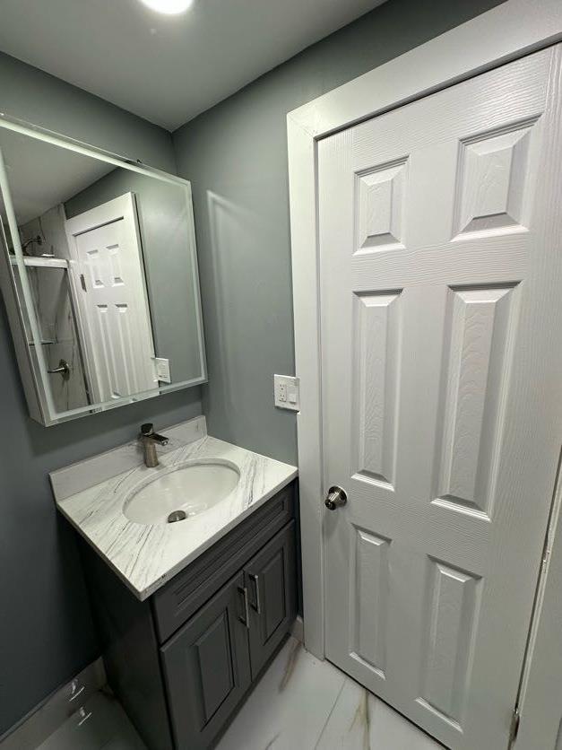 123 Mitchell St, North Bellmore, NY 11710 - bathroom featuring marble finish floors, vanity, and a shower