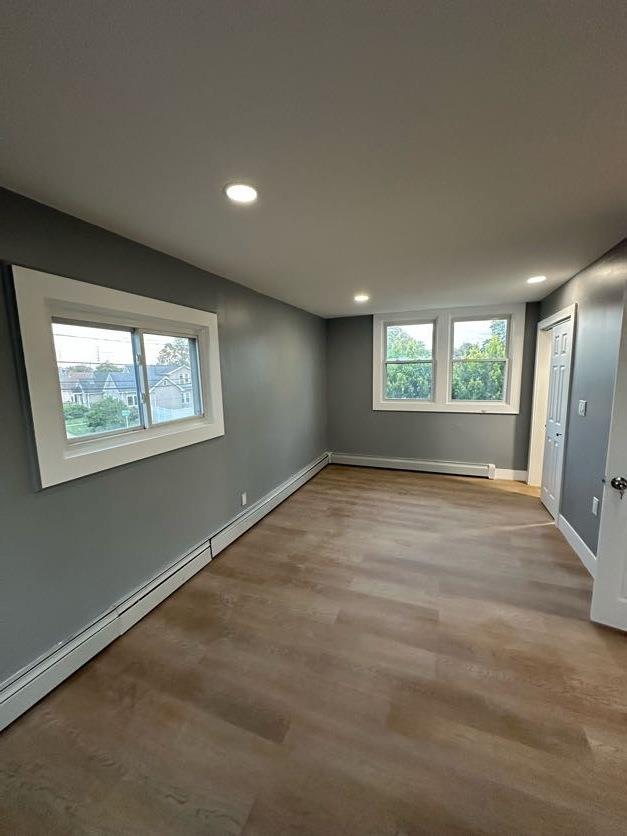 123 Mitchell St, North Bellmore, NY 11710 - unfurnished room featuring recessed lighting, wood finished floors, baseboard heating, and baseboards