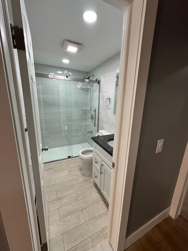 123 Mitchell St, North Bellmore, NY 11710 - full bathroom featuring toilet, a stall shower, vanity, wood finished floors, and recessed lighting