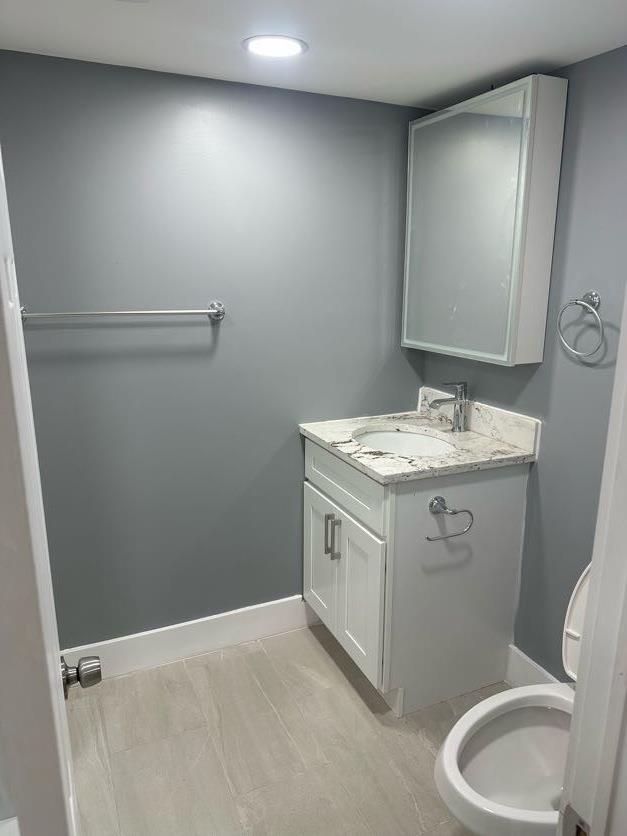 123 Mitchell St, North Bellmore, NY 11710 - half bathroom featuring vanity, baseboards, toilet, and recessed lighting
