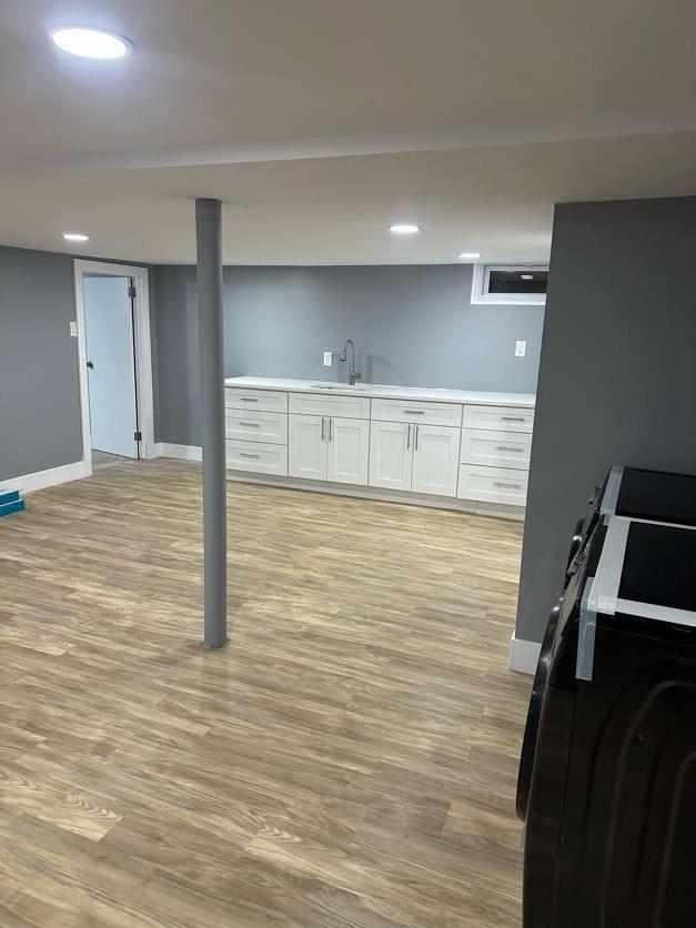 123 Mitchell St, North Bellmore, NY 11710 - finished basement featuring light wood-type flooring, baseboards, recessed lighting, and wet bar