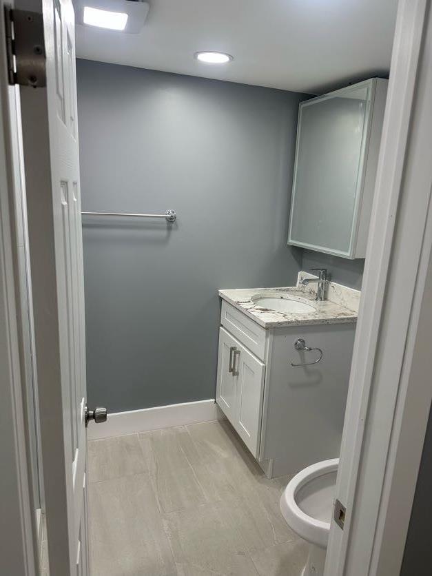 123 Mitchell St, North Bellmore, NY 11710 - half bath with vanity, baseboards, and recessed lighting