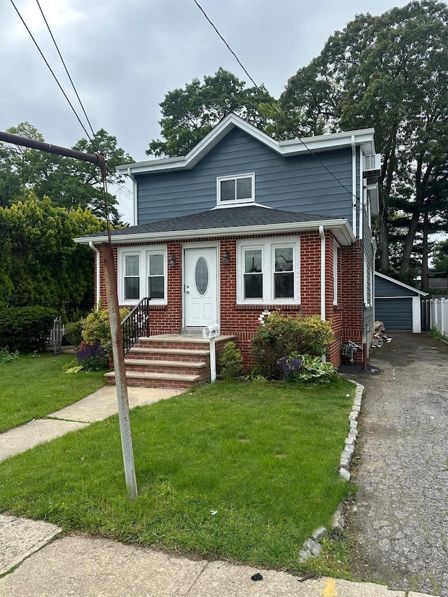123 Mitchell St, North Bellmore, NY 11710 - view of front of property with brick siding, an outdoor structure, a front yard, and a garage