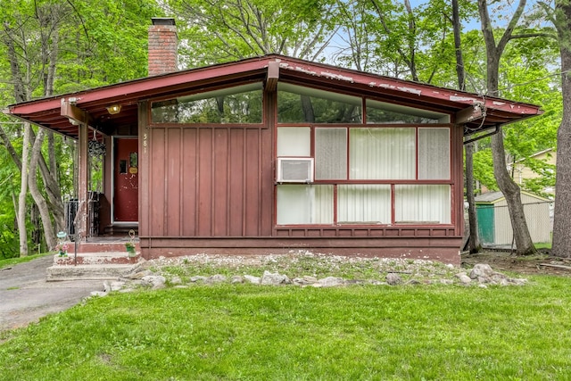 581 Union Rd, Spring Valley, NY 10977 - view of home's exterior featuring a chimney, board and batten siding, a lawn, and cooling unit