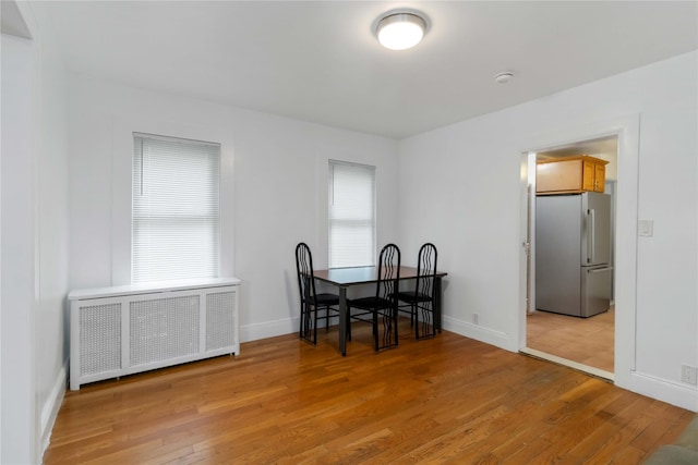 114-18 175th St, Addisleigh Park, NY 11434 - dining room with radiator heating unit, light wood-style floors, and baseboards
