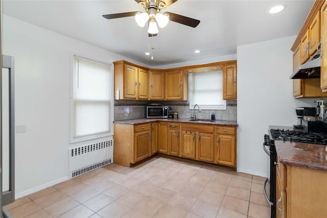114-18 175th St, Addisleigh Park, NY 11434 - kitchen featuring radiator heating unit, stainless steel microwave, under cabinet range hood, gas range, and a sink