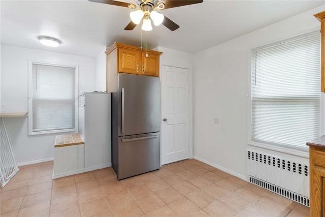 114-18 175th St, Addisleigh Park, NY 11434 - kitchen featuring radiator, freestanding refrigerator, a ceiling fan, baseboards, and light tile patterned floors