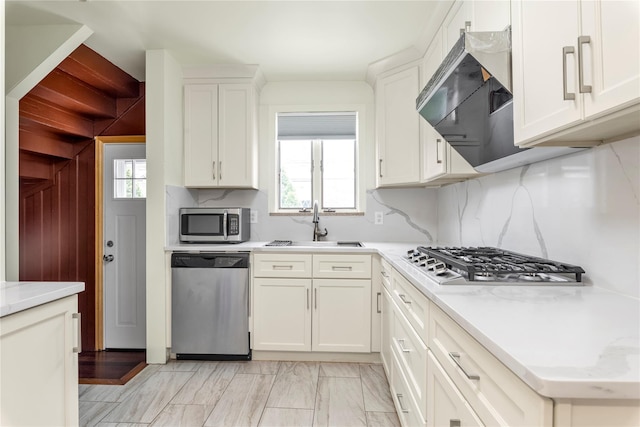 590 Langley Ave, West Hempstead, NY 11552 - kitchen featuring stainless steel appliances, backsplash, a sink, and white cabinets