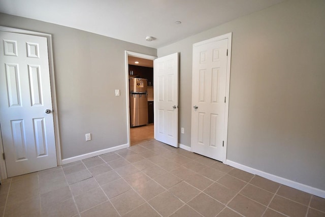 86 Lander St, Newburgh, NY 12550 - unfurnished bedroom with freestanding refrigerator, tile patterned floors, and baseboards