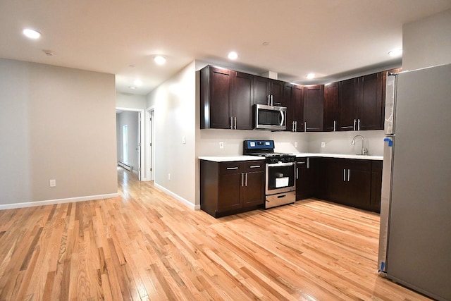86 Lander St, Newburgh, NY 12550 - kitchen featuring stainless steel appliances, light countertops, light wood-style floors, dark brown cabinetry, and recessed lighting