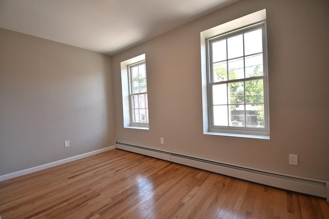 86 Lander St, Newburgh, NY 12550 - spare room with a baseboard heating unit, light wood-style flooring, and baseboards
