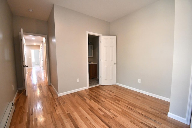 86 Lander St, Newburgh, NY 12550 - unfurnished bedroom featuring a baseboard radiator, light wood finished floors, baseboards, and ensuite bath