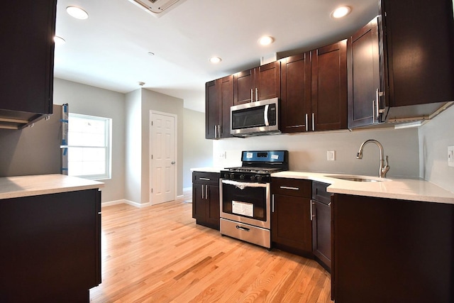 86 Lander St, Newburgh, NY 12550 - kitchen with stainless steel appliances, light countertops, light wood-style flooring, dark brown cabinets, and a sink