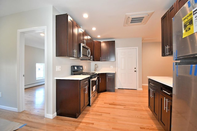 86 Lander St, Newburgh, NY 12550 - kitchen featuring stainless steel appliances, baseboard heating, light wood-style flooring, dark brown cabinetry, and light countertops