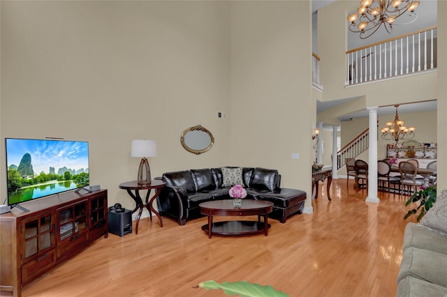 30 Toni Ct Unit 30, Center Moriches, NY 11934 - living area featuring a chandelier, a high ceiling, light wood-type flooring, ornate columns, and stairs