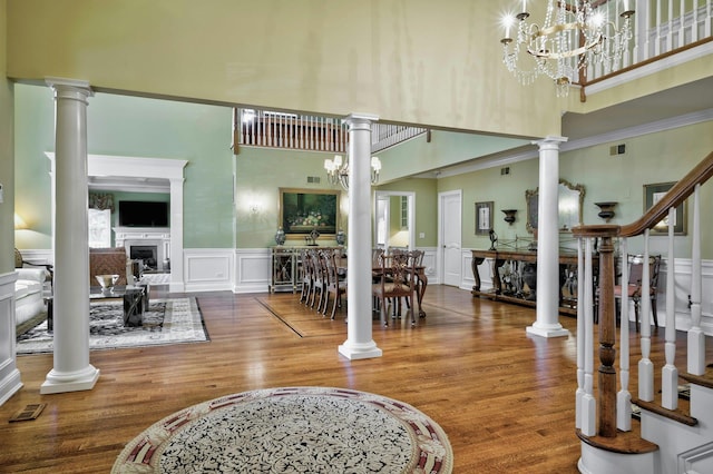 21 Hathaway Ln, Manhasset, NY 11030 - entryway with a high ceiling, a decorative wall, decorative columns, wood finished floors, and a fireplace