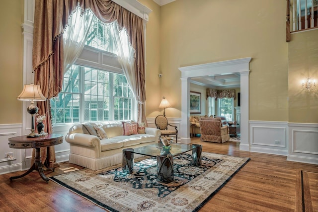 21 Hathaway Ln, Manhasset, NY 11030 - living area featuring a decorative wall, a towering ceiling, wood finished floors, wainscoting, and crown molding