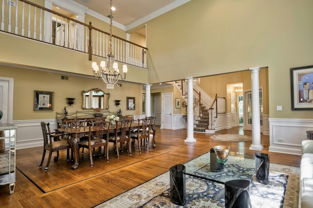 21 Hathaway Ln, Manhasset, NY 11030 - dining space with decorative columns, a towering ceiling, wood finished floors, ornamental molding, and stairway