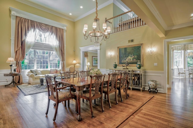 21 Hathaway Ln, Manhasset, NY 11030 - dining room with wood finished floors, a chandelier, a wainscoted wall, crown molding, and a high ceiling