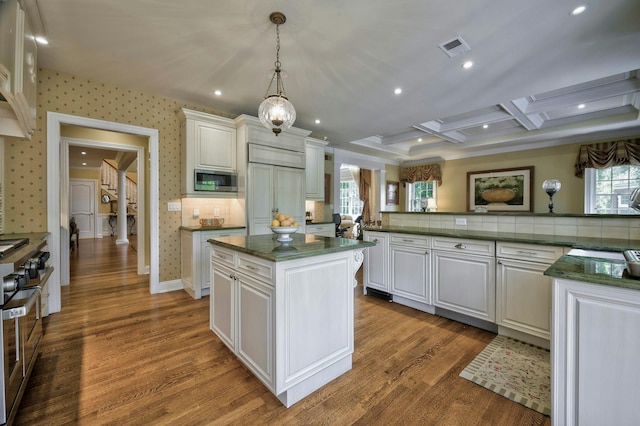 21 Hathaway Ln, Manhasset, NY 11030 - kitchen with stainless steel appliances, a center island, wood finished floors, ornate columns, and white cabinetry