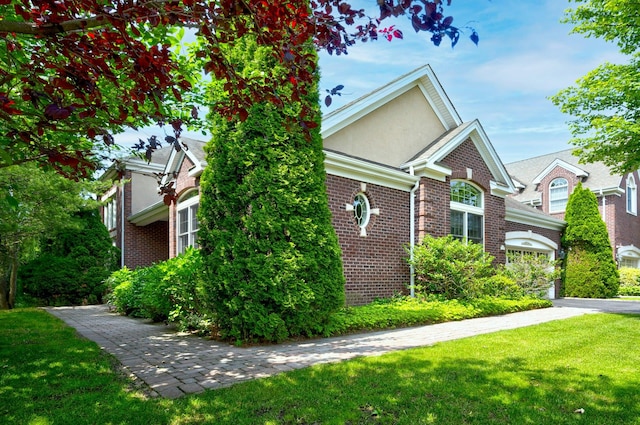 21 Hathaway Ln, Manhasset, NY 11030 - view of home's exterior featuring brick siding, a lawn, and stucco siding