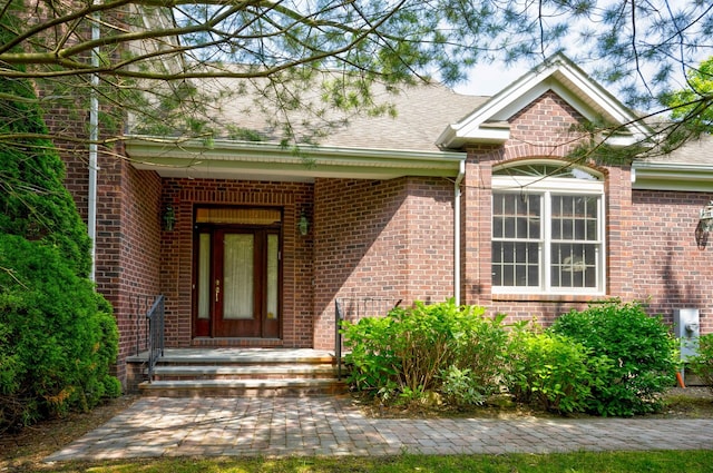 21 Hathaway Ln, Manhasset, NY 11030 - view of exterior entry with brick siding and a shingled roof