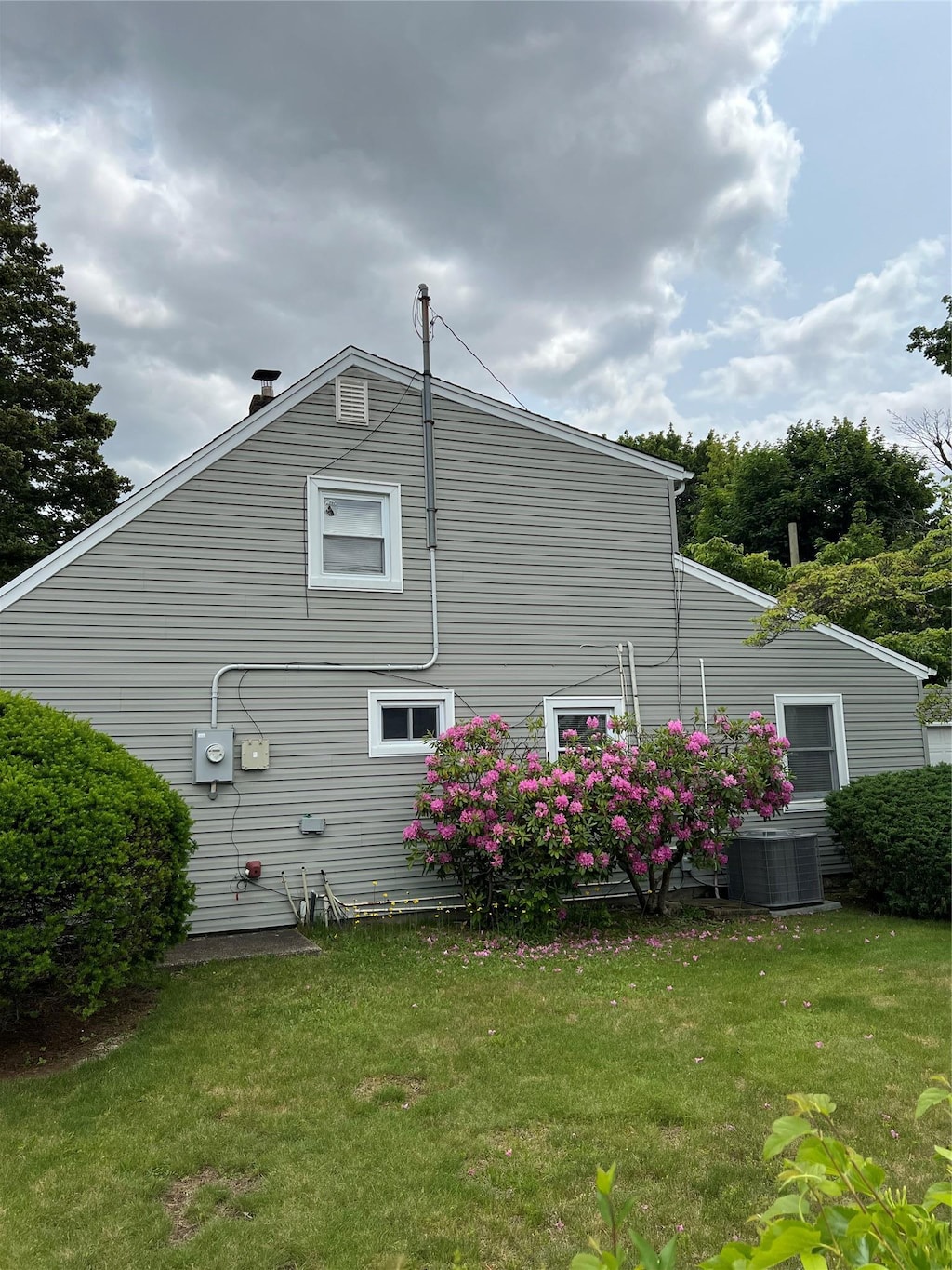 2 Anvil Ln, Levittown, NY 11756 - view of side of home featuring a lawn and cooling unit