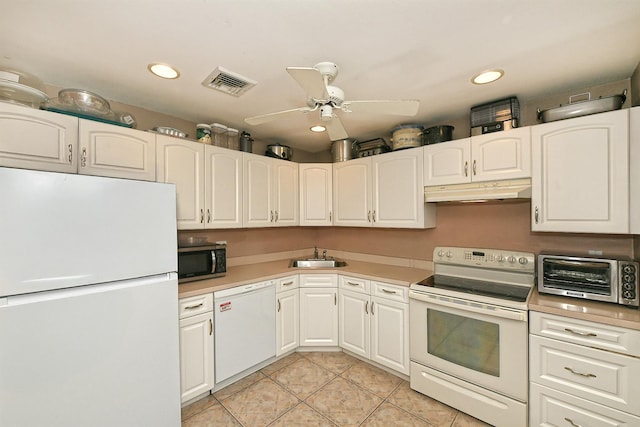 2 Anvil Ln, Levittown, NY 11756 - kitchen featuring white appliances, under cabinet range hood, light tile patterned floors, a sink, and light countertops