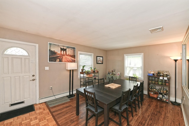 2 Anvil Ln, Levittown, NY 11756 - dining area featuring a baseboard heating unit, healthy amount of natural light, and wood finished floors