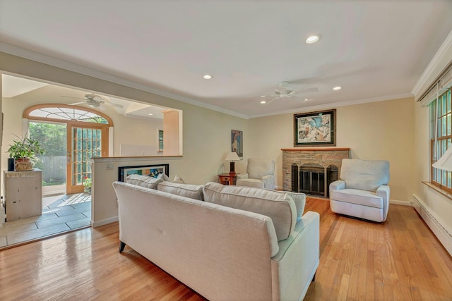 43 Sound Rd, Greenport, NY 11944 - living room featuring a fireplace, a ceiling fan, a baseboard radiator, recessed lighting, and crown molding