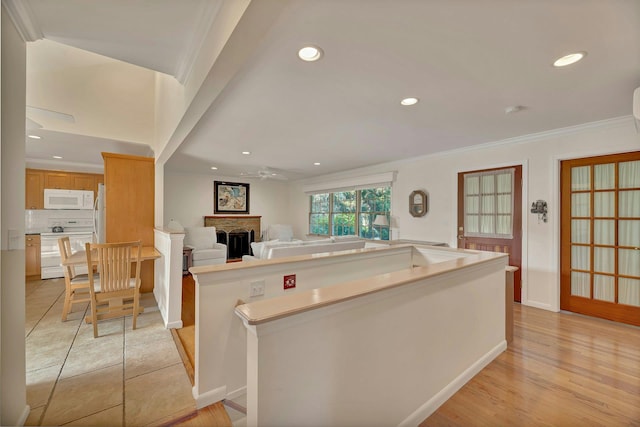 43 Sound Rd, Greenport, NY 11944 - kitchen featuring white appliances, a fireplace, crown molding, a ceiling fan, and light countertops