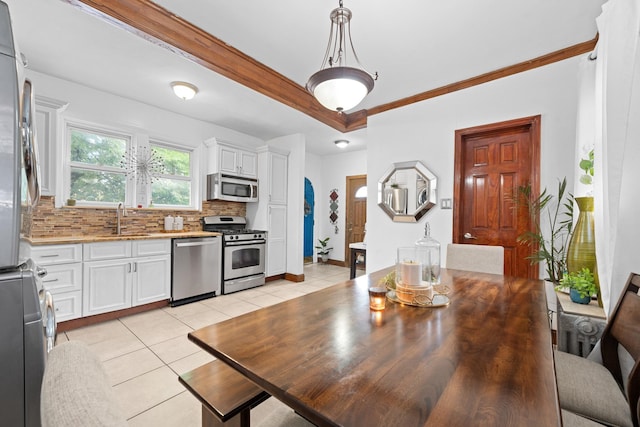 11401 115th St, South Ozone Park, NY 11420 - kitchen with appliances with stainless steel finishes, a sink, backsplash, white cabinets, and ornamental molding