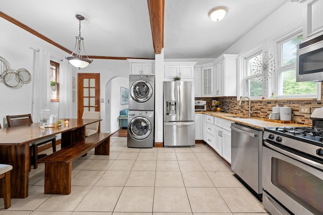 11401 115th St, South Ozone Park, NY 11420 - kitchen featuring appliances with stainless steel finishes, stacked washer / dryer, a sink, and tasteful backsplash