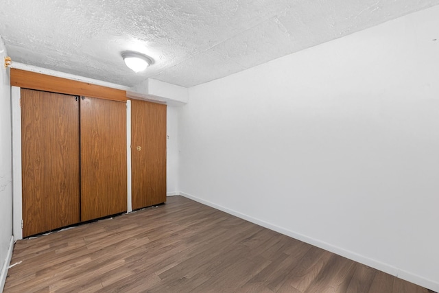 11401 115th St, South Ozone Park, NY 11420 - unfurnished bedroom featuring wood finished floors, baseboards, a textured ceiling, and a closet