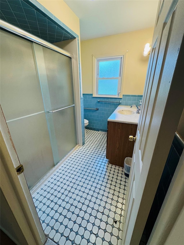 8 Hom St, Chester, NY 10918 - bathroom featuring tile walls, vanity, toilet, wainscoting, and a stall shower