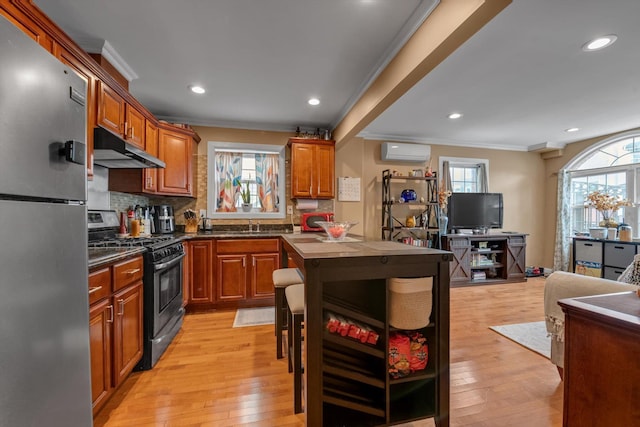 90 Milford St, Brooklyn, NY 11208 - kitchen with appliances with stainless steel finishes, under cabinet range hood, ornamental molding, a wall mounted air conditioner, and healthy amount of natural light