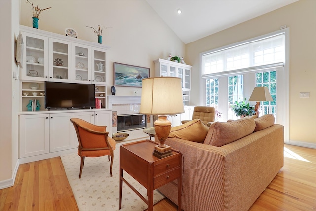 144 Burr Farms Rd, Mount Kisco, NY 10549 - living area with light wood-style flooring, a glass covered fireplace, recessed lighting, high vaulted ceiling, and baseboards