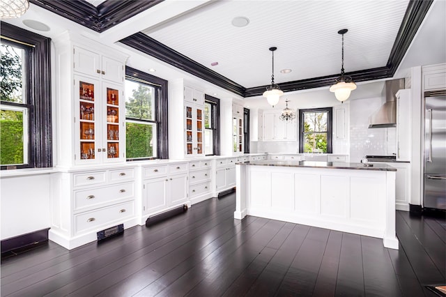 150 Senix Ave, Center Moriches, NY 11934 - kitchen with wall chimney range hood, white cabinets, built in refrigerator, a center island, and dark wood finished floors