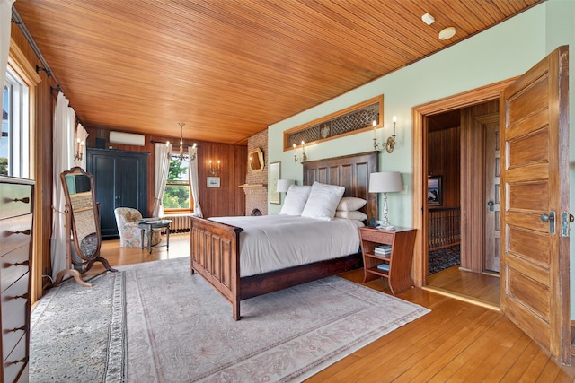 150 Senix Ave, Center Moriches, NY 11934 - bedroom featuring a wall mounted AC, a chandelier, wooden ceiling, and hardwood / wood-style floors