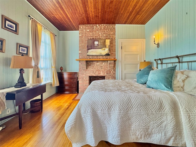 150 Senix Ave, Center Moriches, NY 11934 - bedroom featuring wooden ceiling, wood-type flooring, wood walls, and a fireplace
