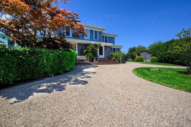 150 Senix Ave, Center Moriches, NY 11934 - view of front facade featuring curved driveway, a storage shed, and a porch