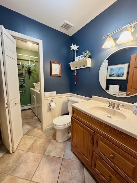 73 Gregory Way, Calverton, NY 11933 - bathroom with vanity, wainscoting, toilet, a shower, and baseboard heating