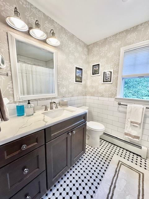 73 Gregory Way, Calverton, NY 11933 - full bath featuring wallpapered walls, a baseboard radiator, vanity, a wainscoted wall, and toilet