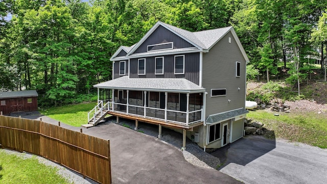 11 Fieldstone Ct, Highland, NY 12528 - rear view of house with a sunroom, a shingled roof, a patio, and a wooded view