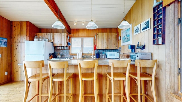 15 Dune Walk, Davis Park, NY 11772 - kitchen with white appliances, wood walls, light wood-style flooring, rail lighting, and a peninsula