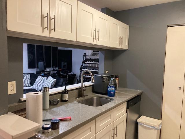 615 Broadway Unit 11, Amityville, NY 11701 - kitchen featuring a sink, dishwasher, white cabinetry, and light stone countertops