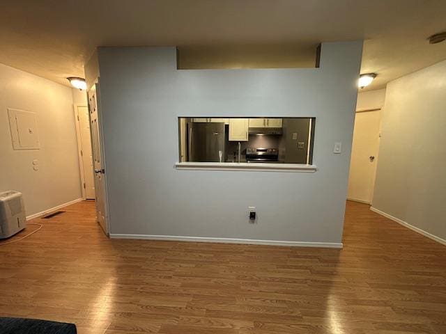 615 Broadway Unit 11, Amityville, NY 11701 - unfurnished living room featuring wood finished floors, baseboards, and electric panel