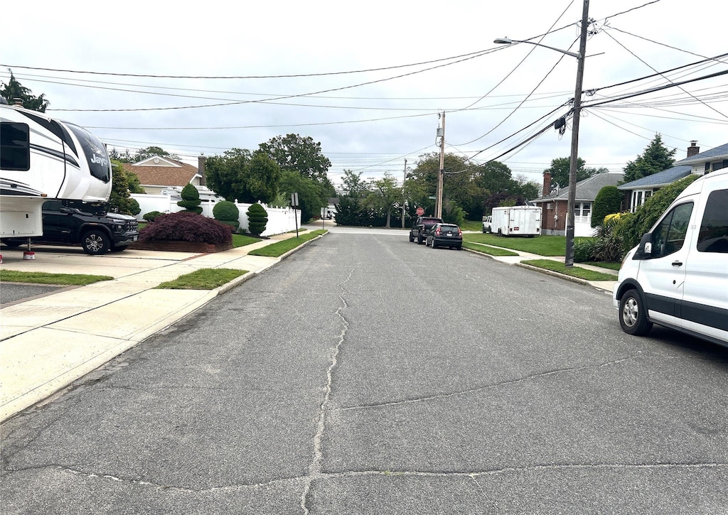 11 Berryhill Ln, Bethpage, NY 11714 - view of asphalt road featuring sidewalks, curbs, and a residential view