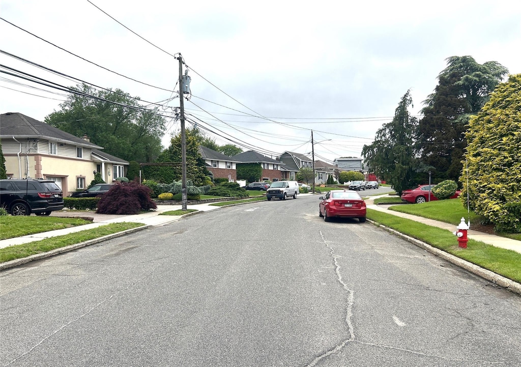 11 Berryhill Ln, Bethpage, NY 11714 - view of asphalt road with sidewalks, curbs, a residential view, and street lights
