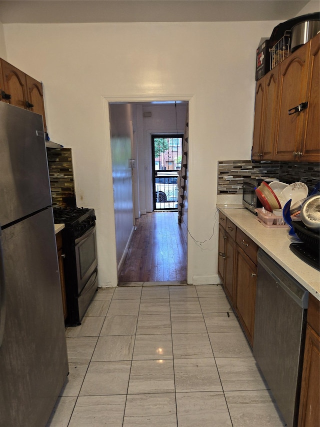 731 E 218th St, Bronx, NY 10467 - kitchen with appliances with stainless steel finishes, tasteful backsplash, light countertops, and light tile patterned floors